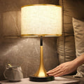 Lampa stołowa w stylu retro z plecionym abażurem i złotym podstawkiem w kształcie trąbki